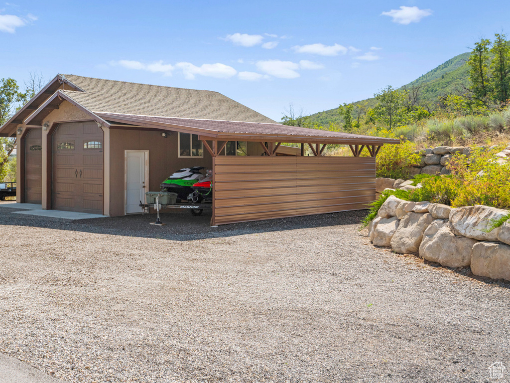 View of side of home with a mountain view and a carport