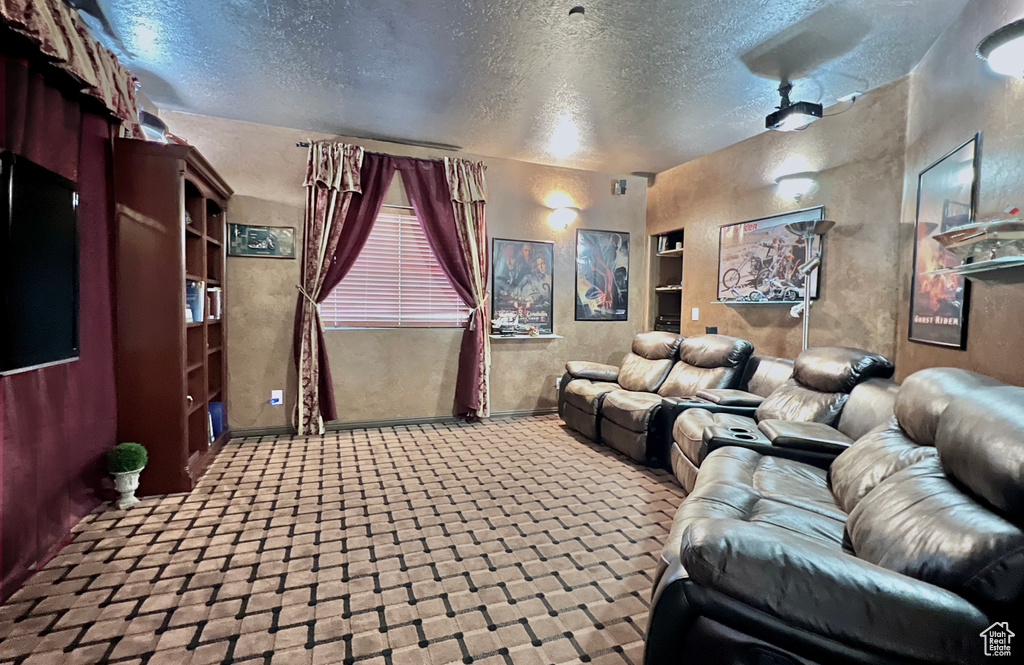 Home theater room featuring a textured ceiling