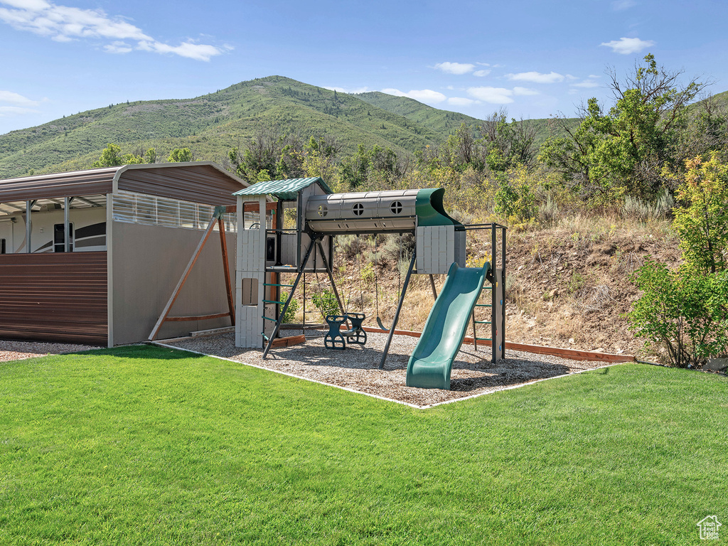 View of jungle gym featuring a yard and a mountain view