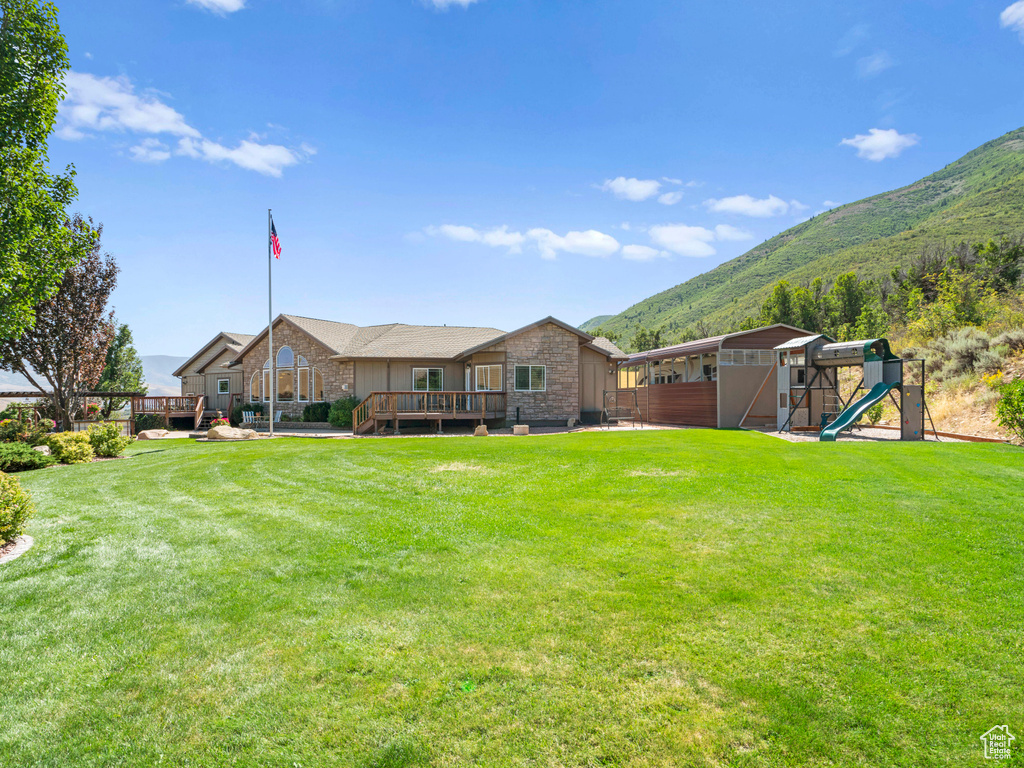 View of yard with a deck with mountain view