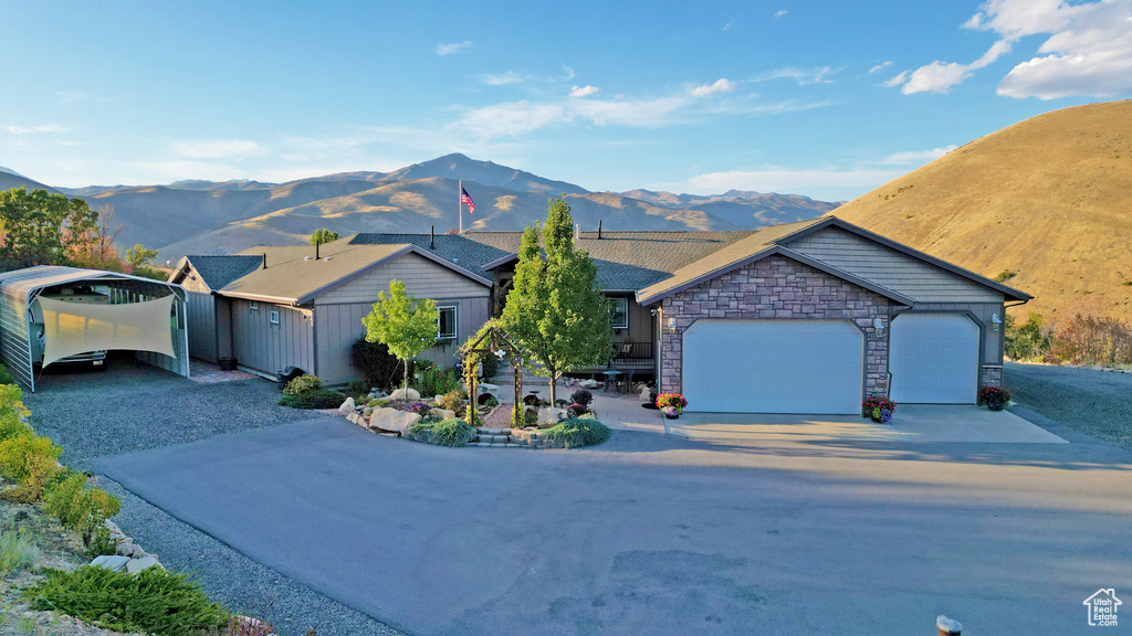 Single story home with a garage, a carport, and a mountain view