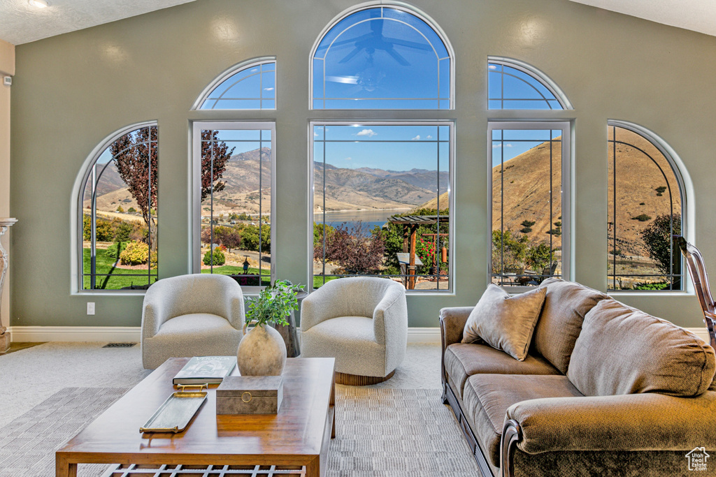 Living room with a mountain view, plenty of natural light, and carpet flooring