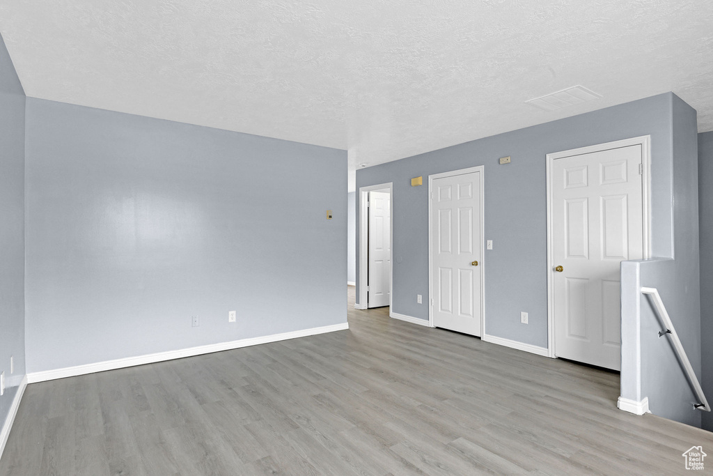 Unfurnished room featuring a textured ceiling and light wood-type flooring