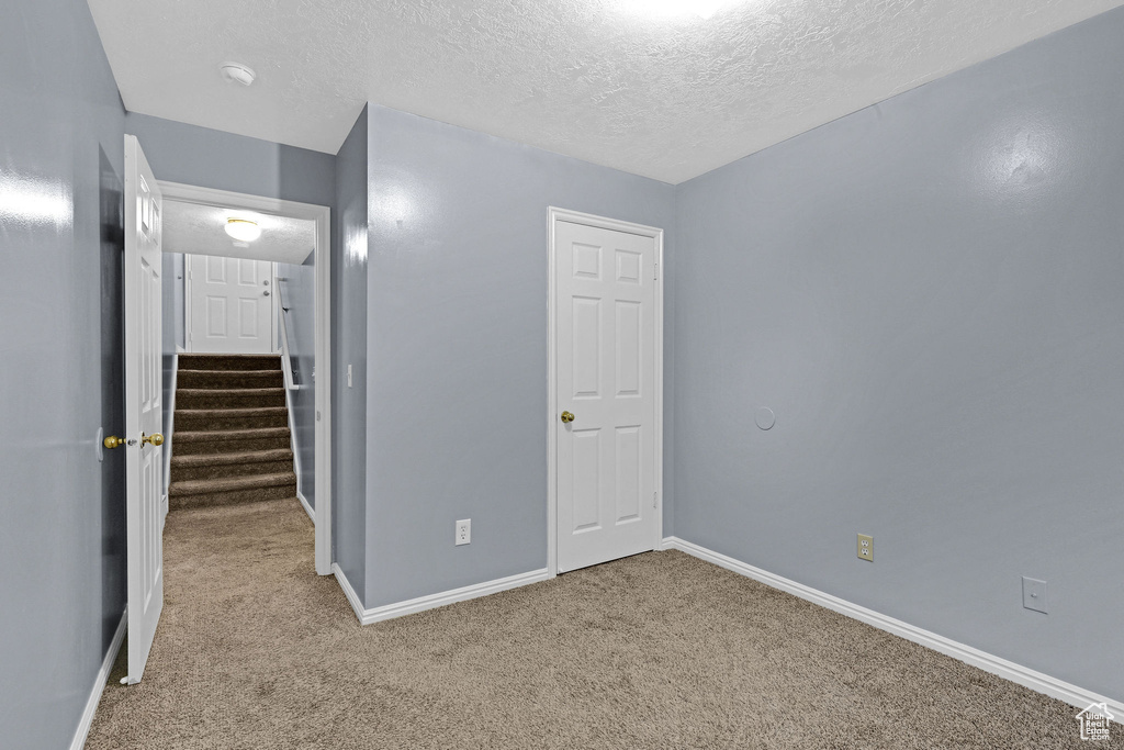 Interior space with a textured ceiling and light carpet