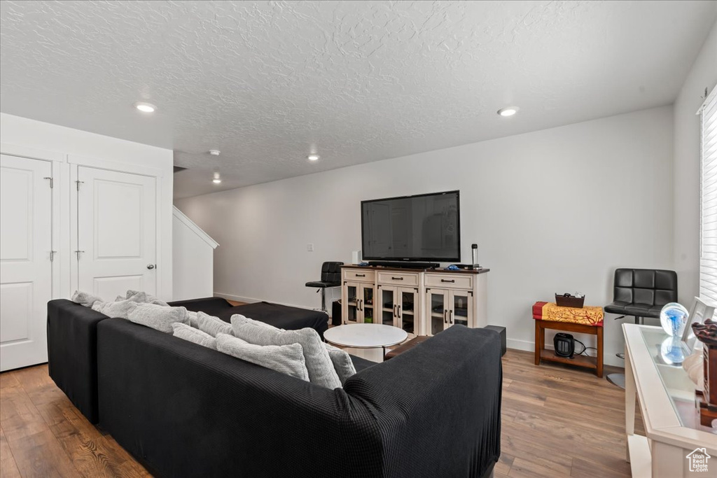 Living room featuring a textured ceiling and light wood-type flooring