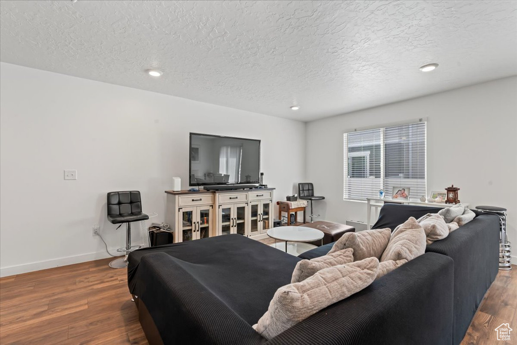 Living room with hardwood / wood-style floors and a textured ceiling