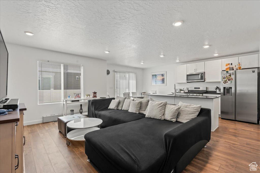 Living room with hardwood / wood-style flooring and a textured ceiling