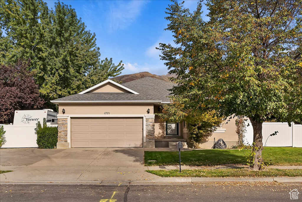 View of front of home with a garage and a front lawn