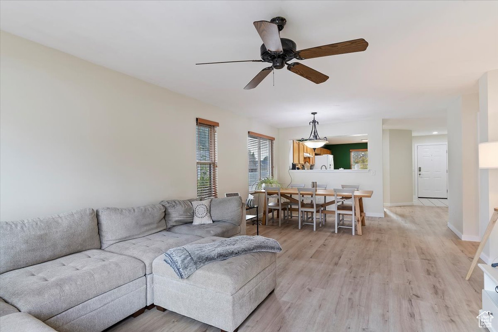 Living room with light hardwood / wood-style flooring and ceiling fan