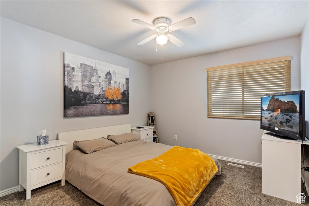 Bedroom with ceiling fan and dark carpet