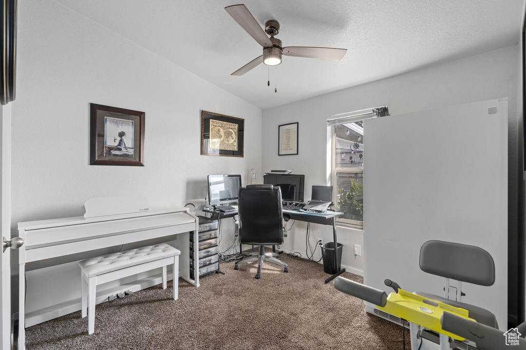 Carpeted office featuring ceiling fan and vaulted ceiling