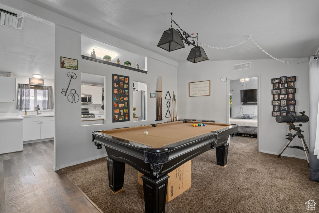 Rec room featuring dark wood-type flooring, vaulted ceiling, sink, and billiards