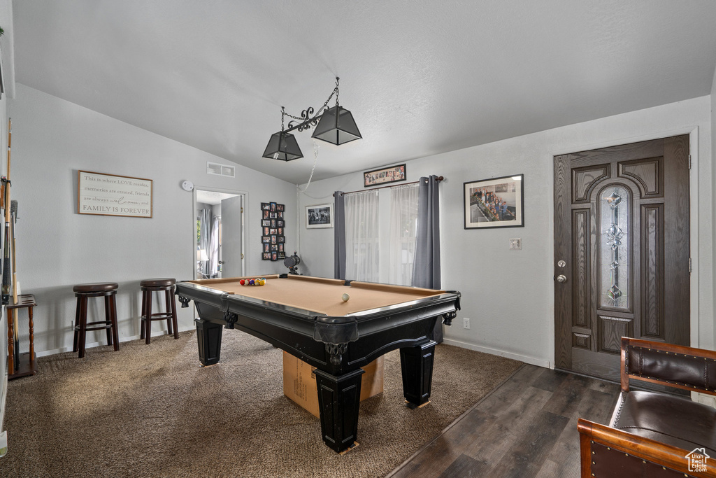 Game room with pool table, dark wood-type flooring, and vaulted ceiling