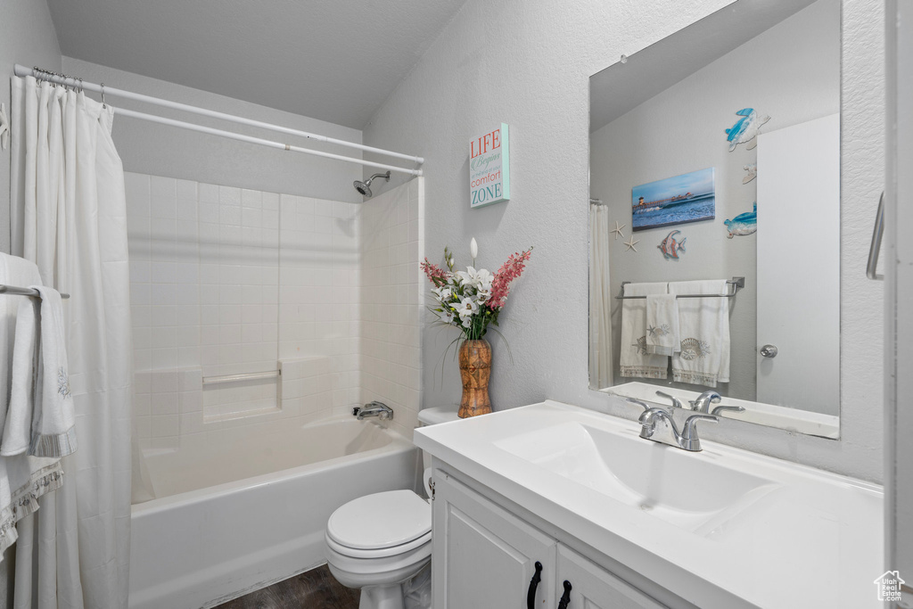 Full bathroom with wood-type flooring, vanity, toilet, and shower / bath combo