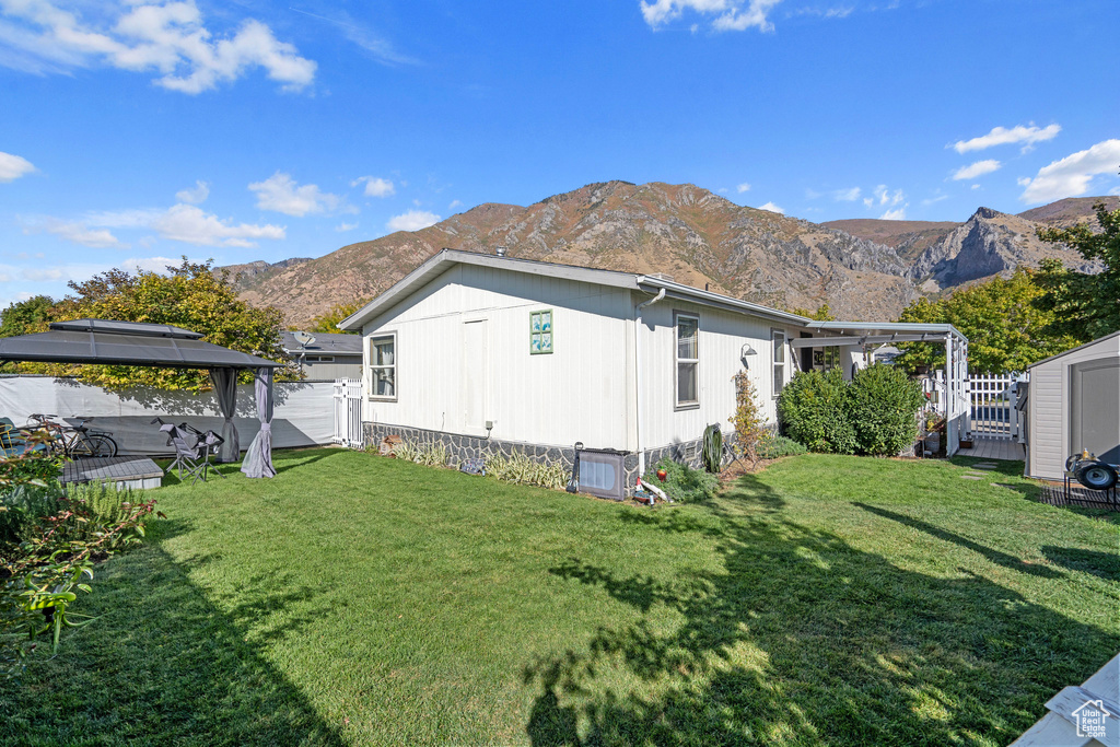 View of side of property with a gazebo, a yard, and a mountain view