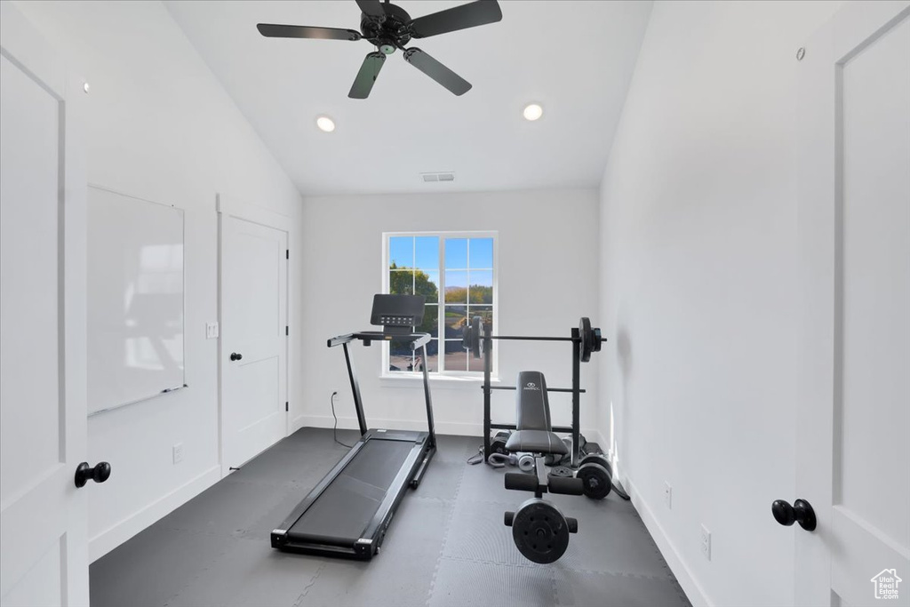 Workout area featuring ceiling fan and vaulted ceiling