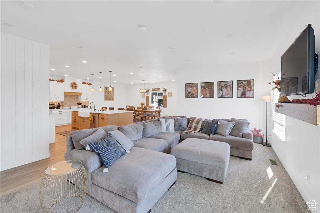 Living room with light wood-type flooring and sink