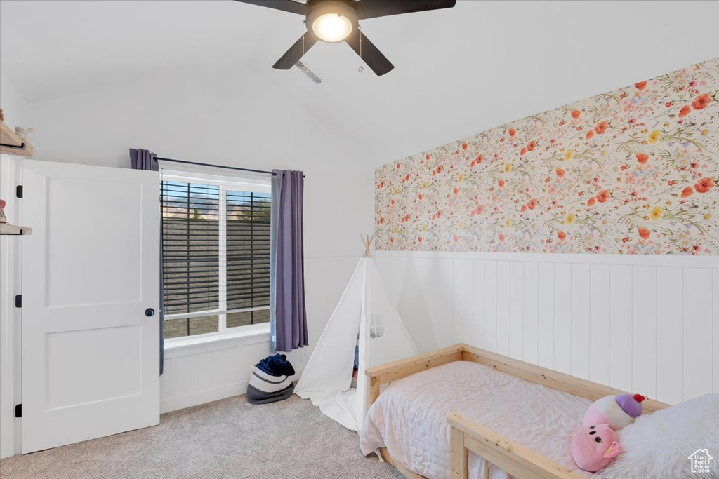 Bedroom featuring ceiling fan, carpet floors, lofted ceiling, and multiple windows