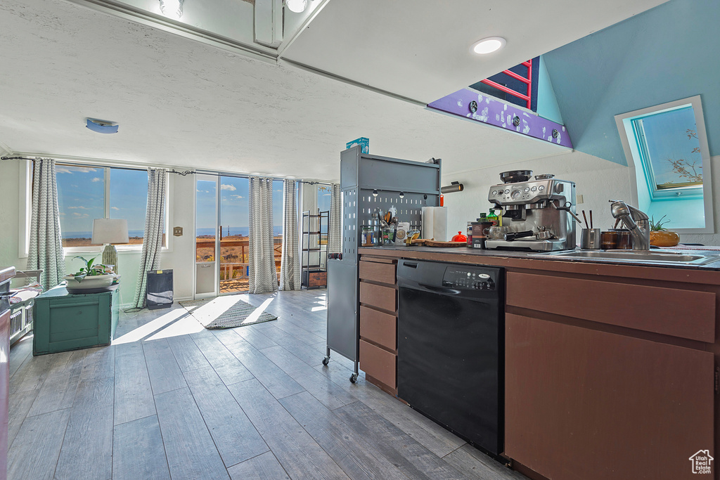 Kitchen featuring wood-type flooring, dishwasher, and sink