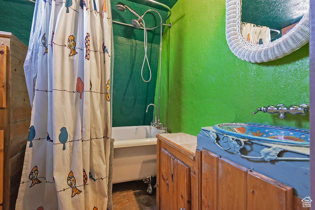 Bathroom featuring sink, tile patterned flooring, and shower / bath combination with curtain