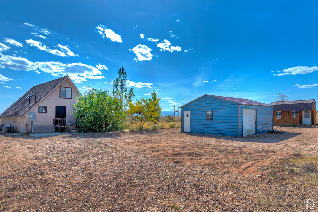 View of yard featuring a garage and an outdoor structure