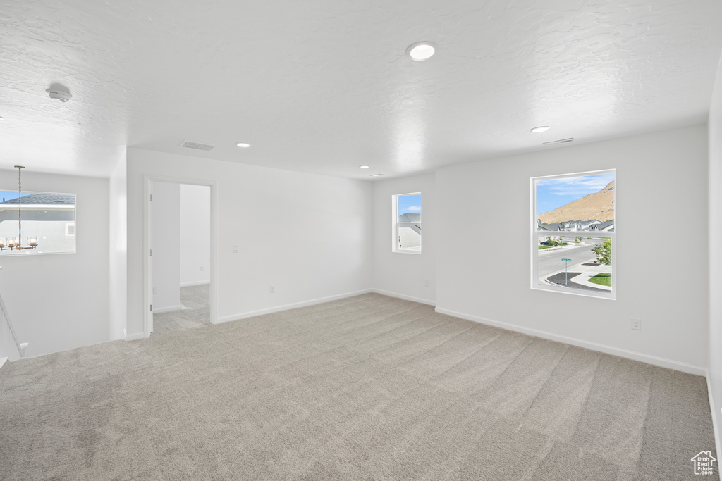 Spare room featuring light carpet and a textured ceiling