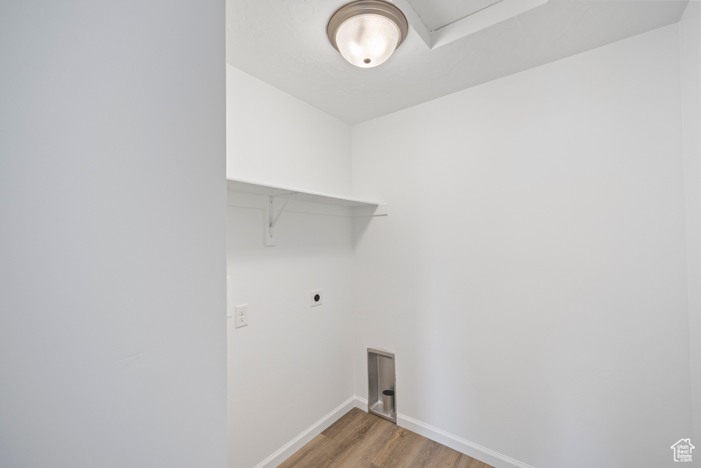 Laundry room with hookup for an electric dryer and hardwood / wood-style flooring