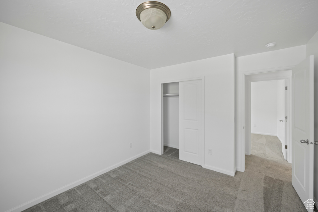 Unfurnished bedroom with a closet and light colored carpet