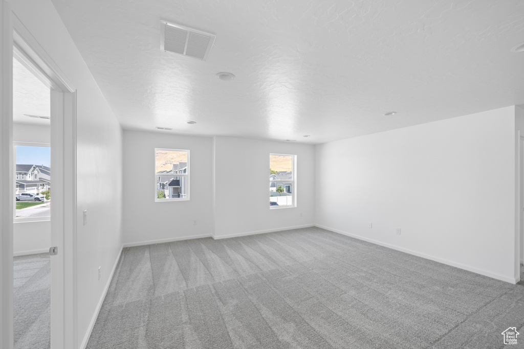 Carpeted empty room featuring a textured ceiling