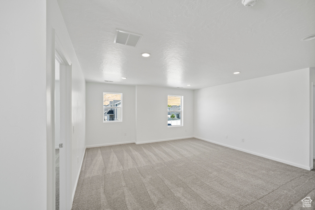 Carpeted spare room with a textured ceiling