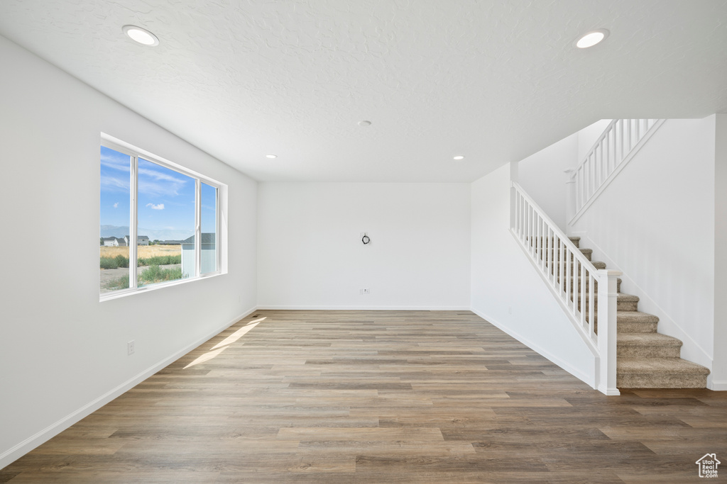 Empty room featuring a textured ceiling and hardwood / wood-style flooring