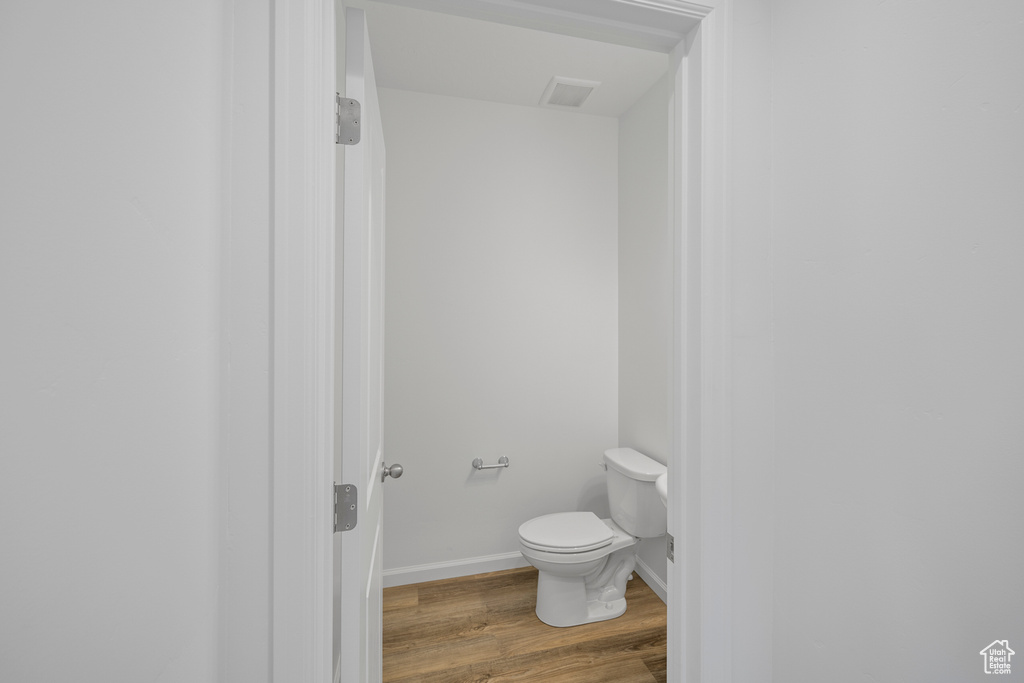 Bathroom with toilet and hardwood / wood-style flooring