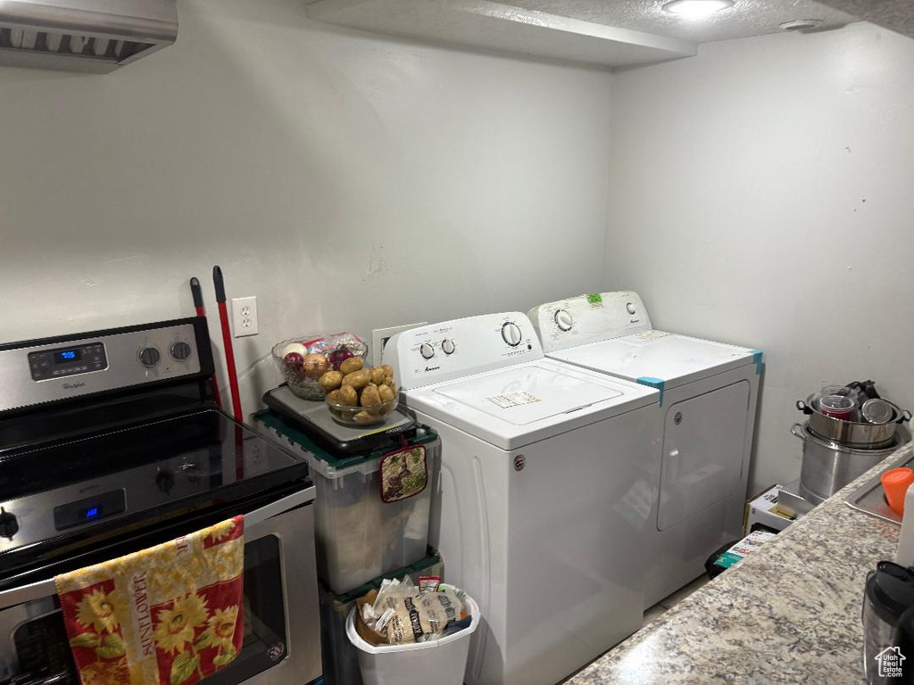 Clothes washing area featuring a textured ceiling and washing machine and clothes dryer