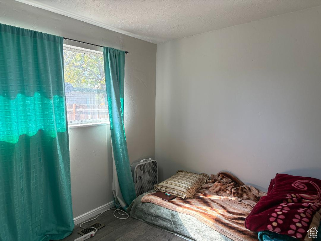 Bedroom featuring hardwood / wood-style flooring and a textured ceiling