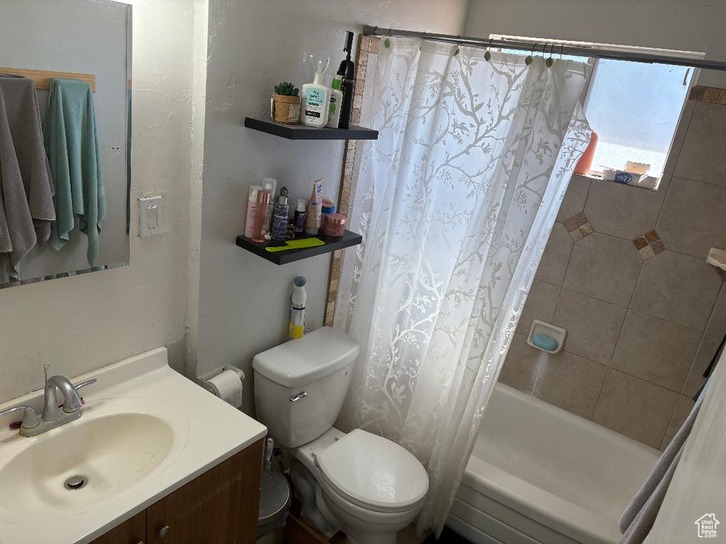 Full bathroom with shower / bath combo, toilet, and vanity