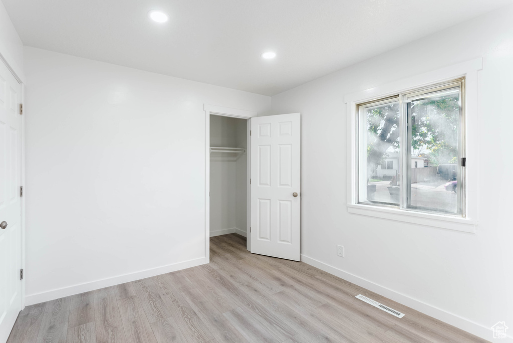 Unfurnished bedroom featuring a closet and light hardwood / wood-style floors