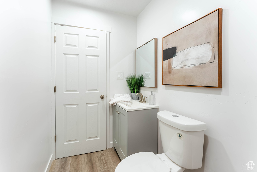 Bathroom featuring hardwood / wood-style floors, vanity, and toilet