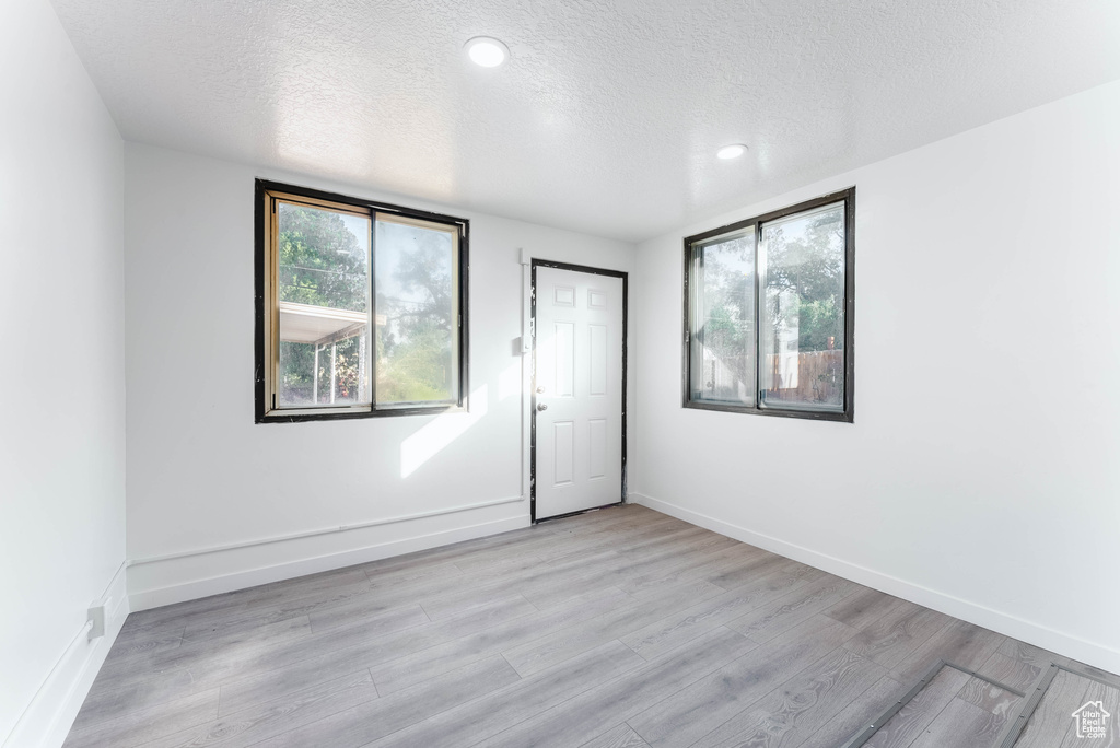 Spare room featuring light hardwood / wood-style flooring and a textured ceiling