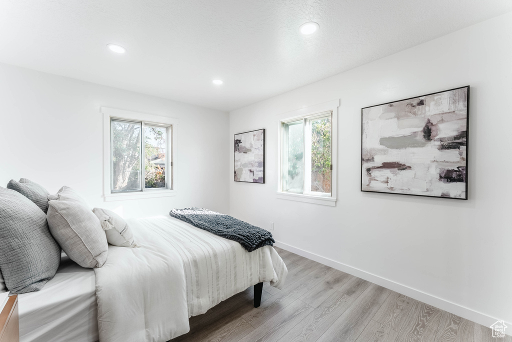 Bedroom with light wood-type flooring and multiple windows