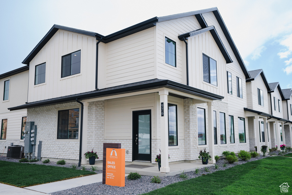 Modern inspired farmhouse with a front yard and cooling unit