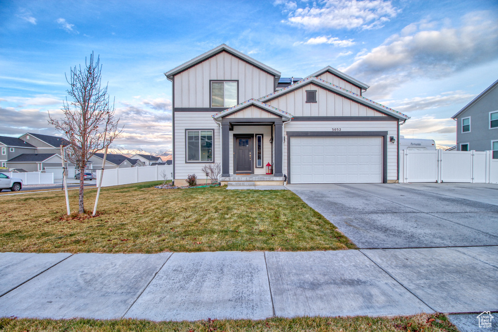 View of front of house with a garage and a front lawn