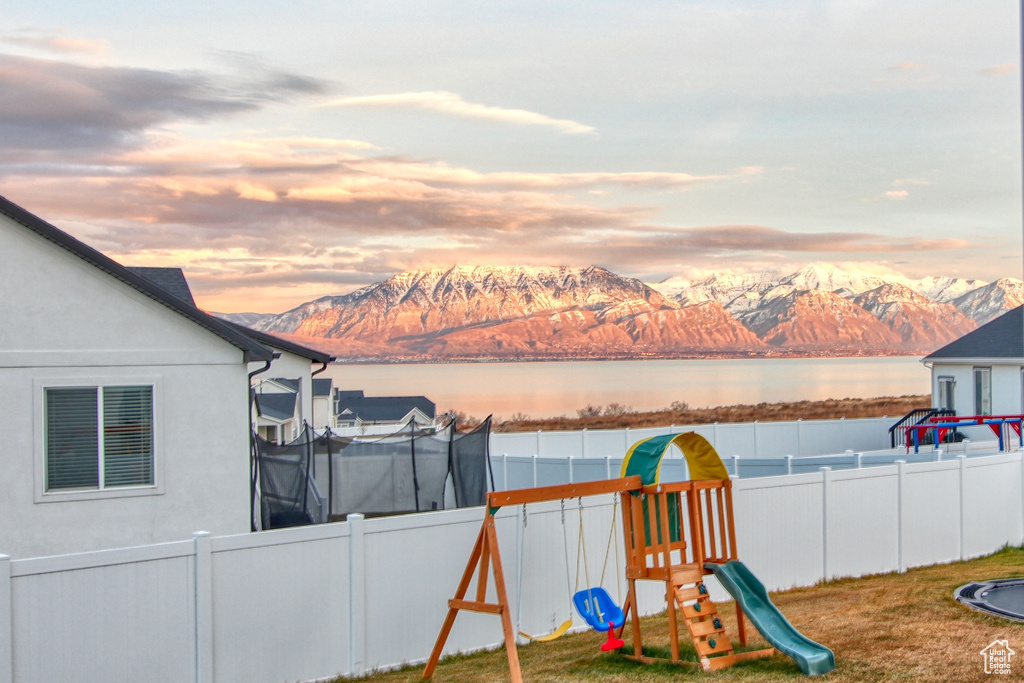 Playground at dusk featuring a water and mountain view