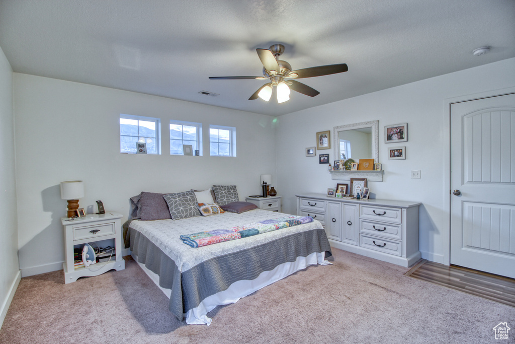 Bedroom with ceiling fan and light colored carpet