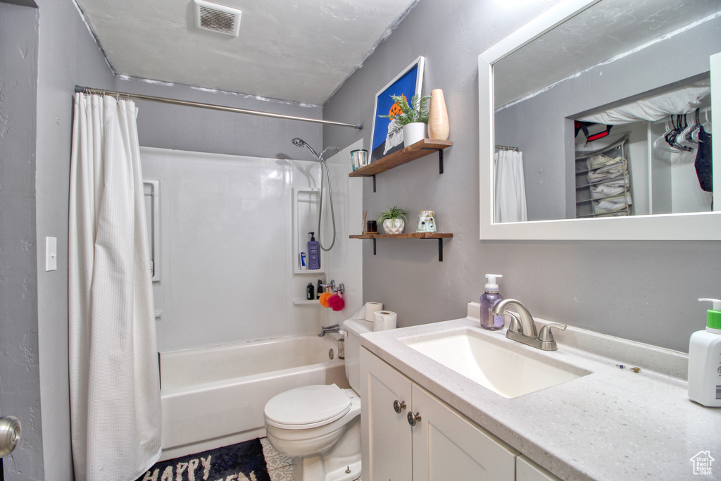 Full bathroom featuring shower / bath combo, vanity, and toilet