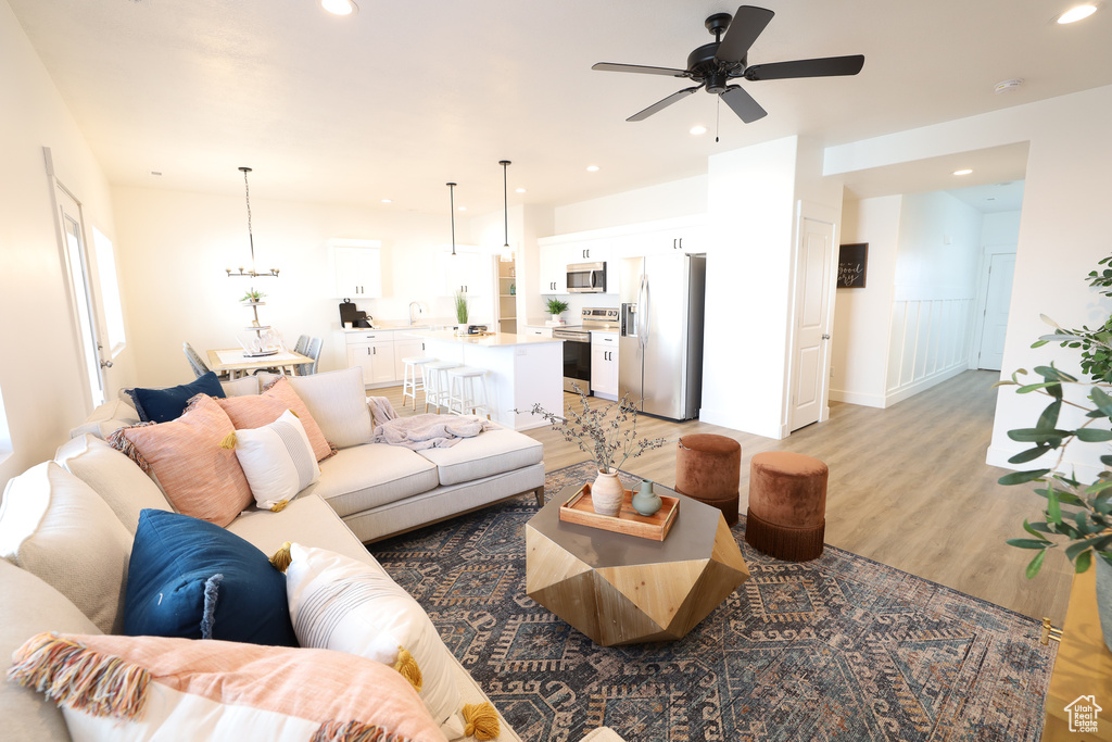 Living room with light hardwood / wood-style floors and ceiling fan