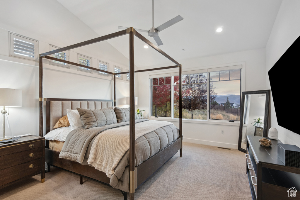 Bedroom with ceiling fan, lofted ceiling, and light carpet