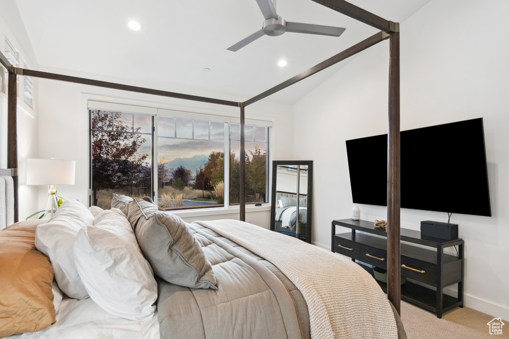 Carpeted bedroom featuring vaulted ceiling and ceiling fan