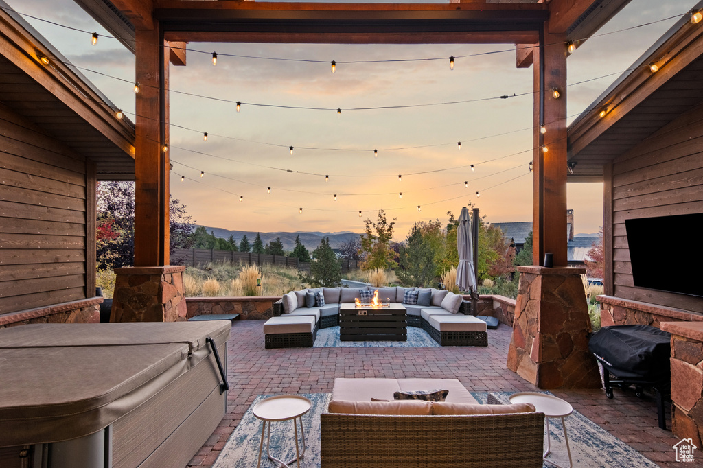 View of patio with an outdoor hangout area and a hot tub