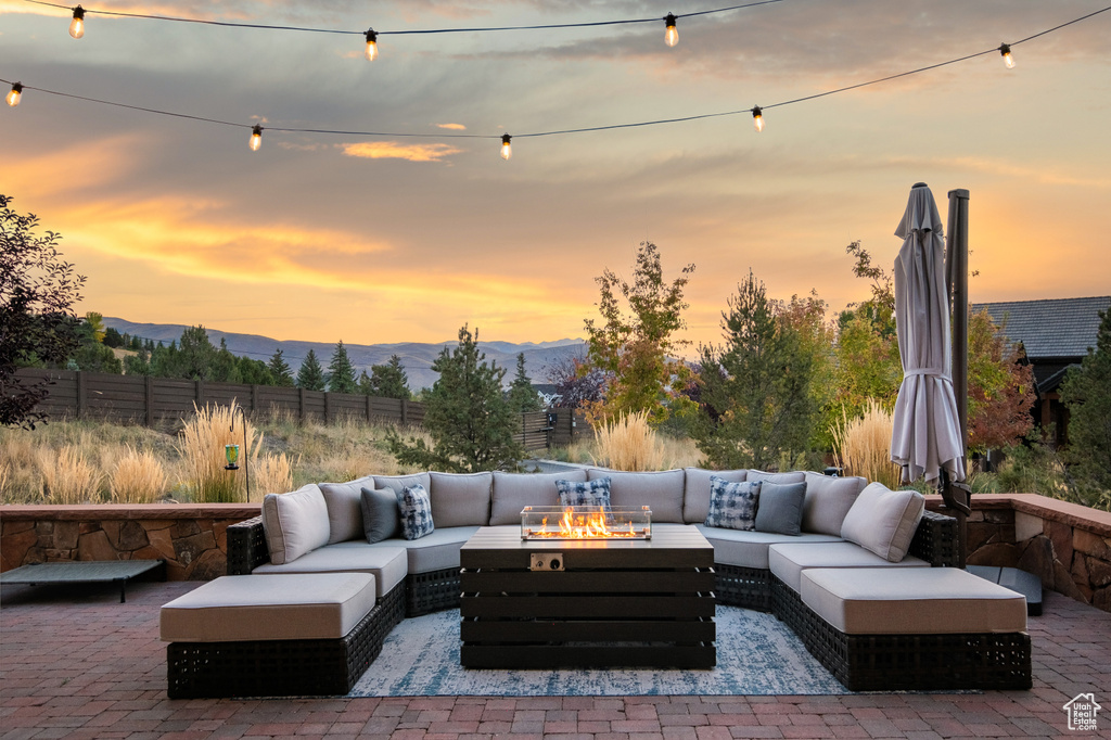 Patio terrace at dusk featuring a mountain view and an outdoor living space with a fire pit