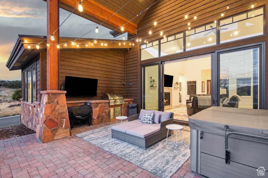 Patio terrace at dusk featuring grilling area